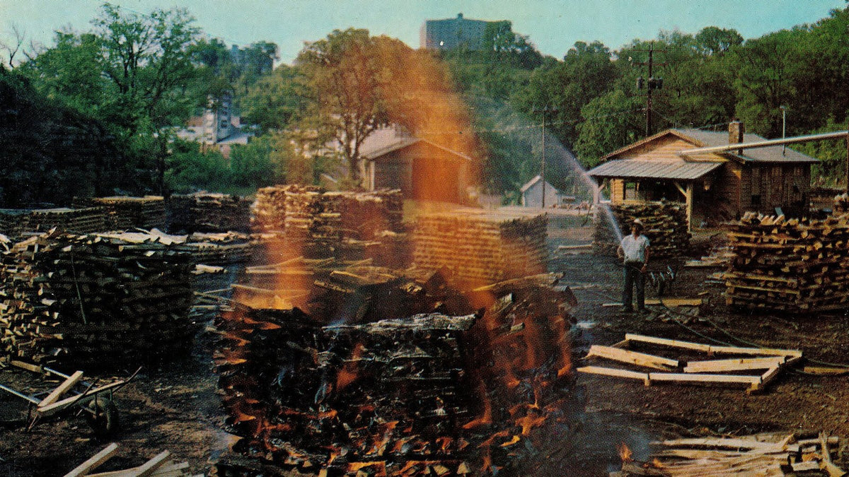 Stacks of sugar-maple wood burning in the open to make charcoal at a Lynchburg, Tennessee distillery.