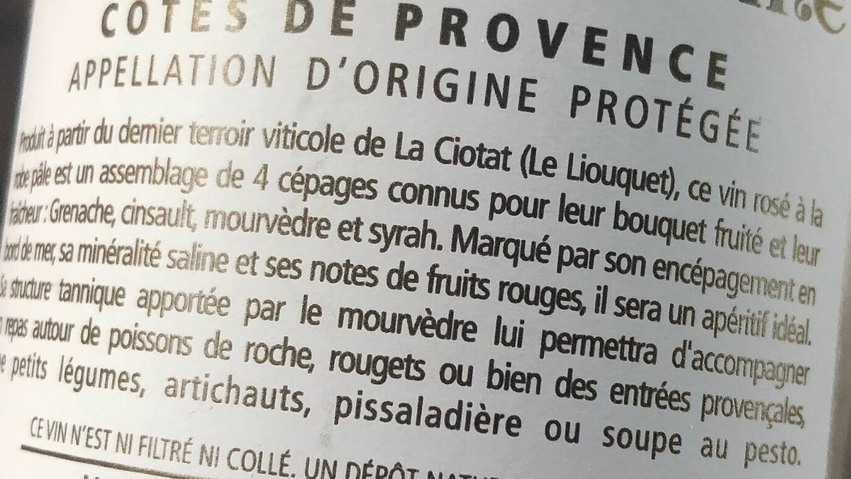 Close-up of a French rose back label reading Cotes de Provence, Appellation d'Origine Protegee, with a printed description of the wine.
