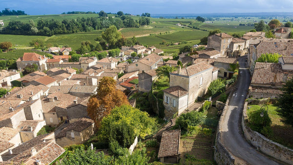 Terracotta rooftops of Saint-Émilion with vineyards stretching beyond the town in Bordeaux.