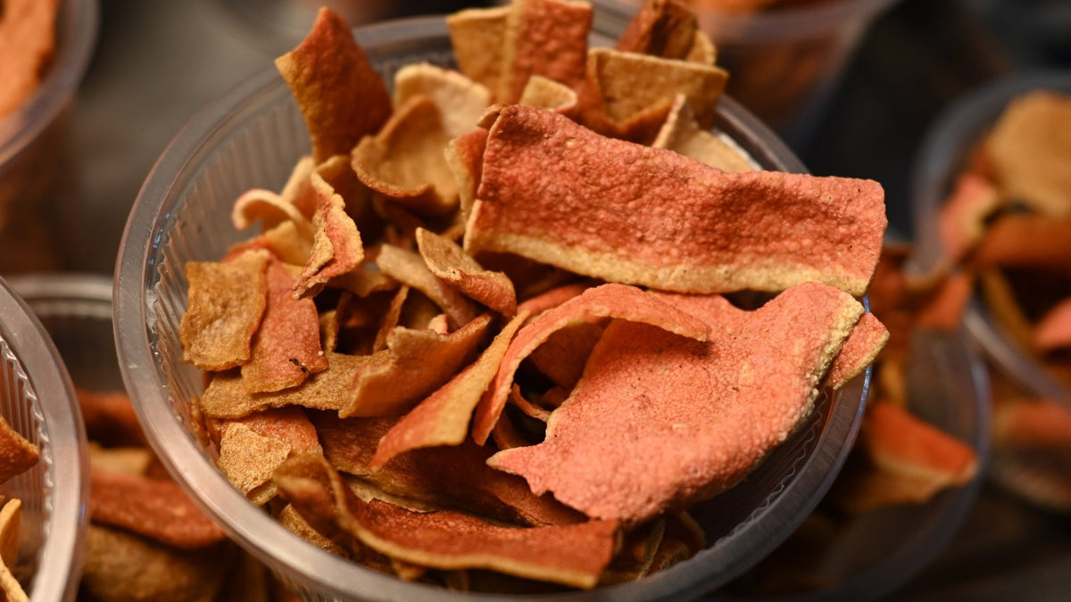 A bowl of curled, dried citrus peel in orange and brown tones.