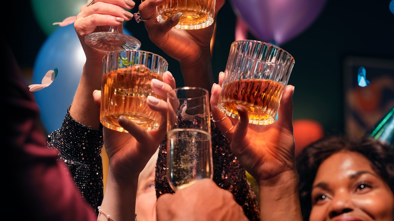 Friends raising glasses in a warm celebratory birthday toast